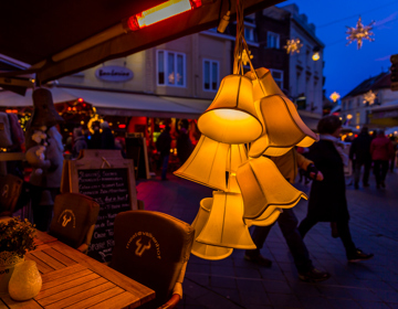 Gele kerstklokken hangen als versiering aan luifel van terras