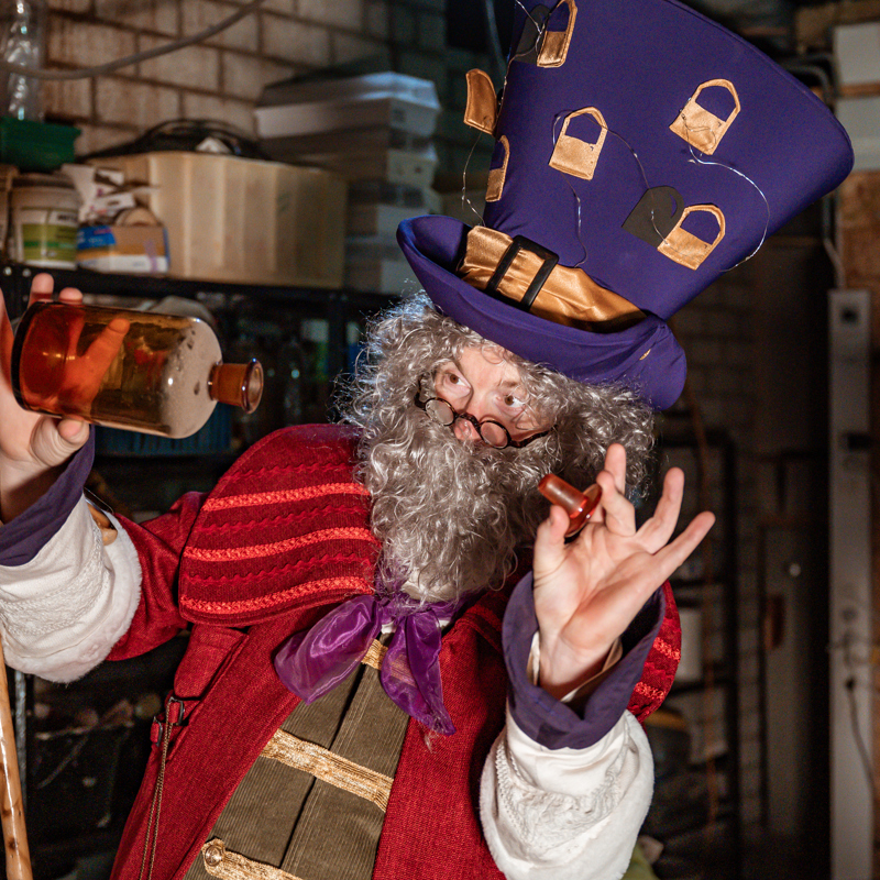 Prof. Dr. Falckenstein kijkend in glazen apothekersfles